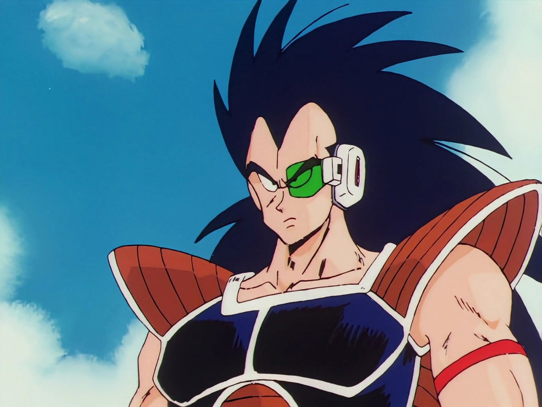 Raditz, met lang, stekelig zwart haar en een groene scouter op zijn linkeroog, in een bruin-zwart pantser met een rode band om zijn arm, tegen een blauwe lucht.