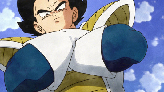 Vegeta, bras croisés dans son armure saiyanne blanche à épaulières jaunes, toise la scène en contre-plongée sur un ciel bleu nuageux.